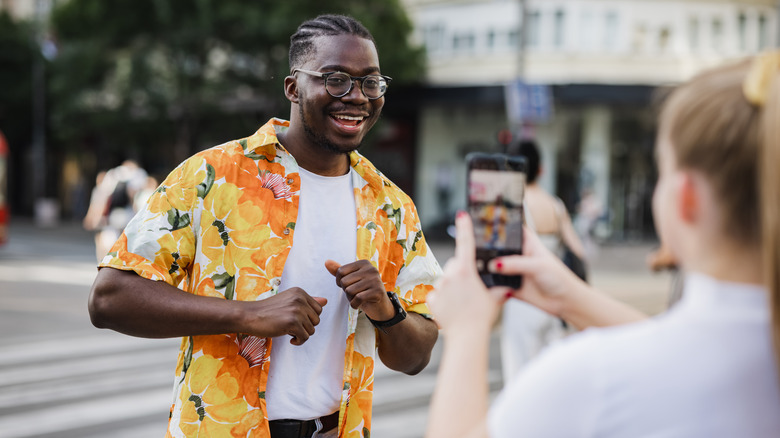 smiling people taking smartphone photos