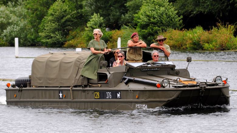 People riding in a DUKW on the water