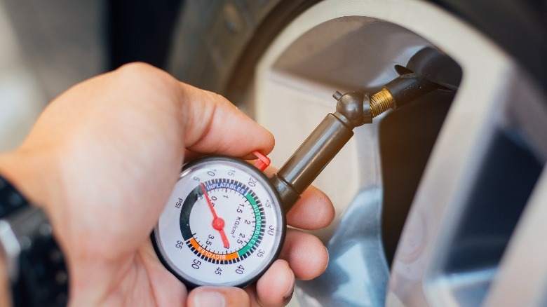 Checking tire pressure with a tire pressure guage