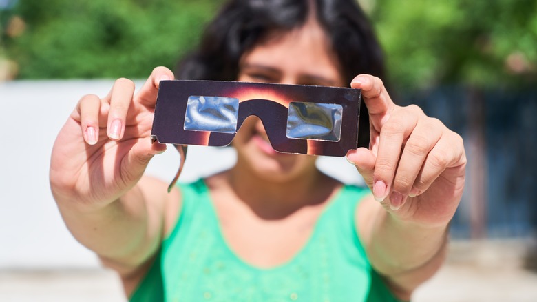 Person holding a solar eye filter
