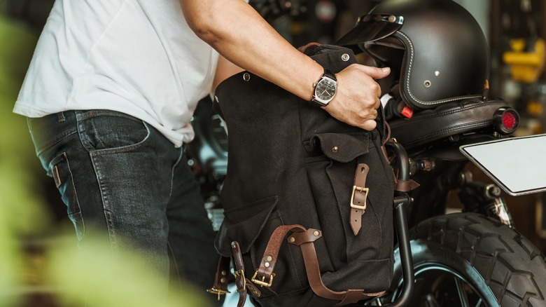 Man installing saddlebags on motorcycle