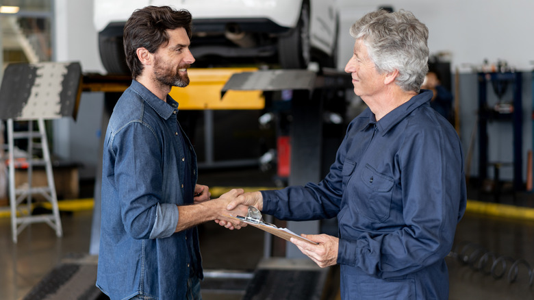 customer shaking hands with auto mechanic