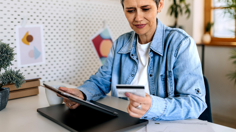 woman using card holding tablet