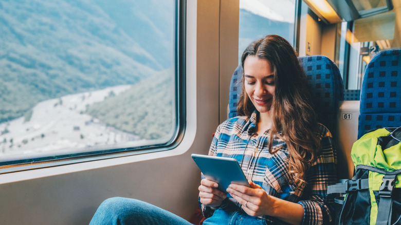 woman watching tablet on train