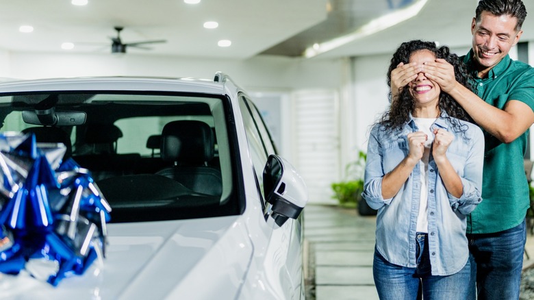 Man surprising a woman with car gift