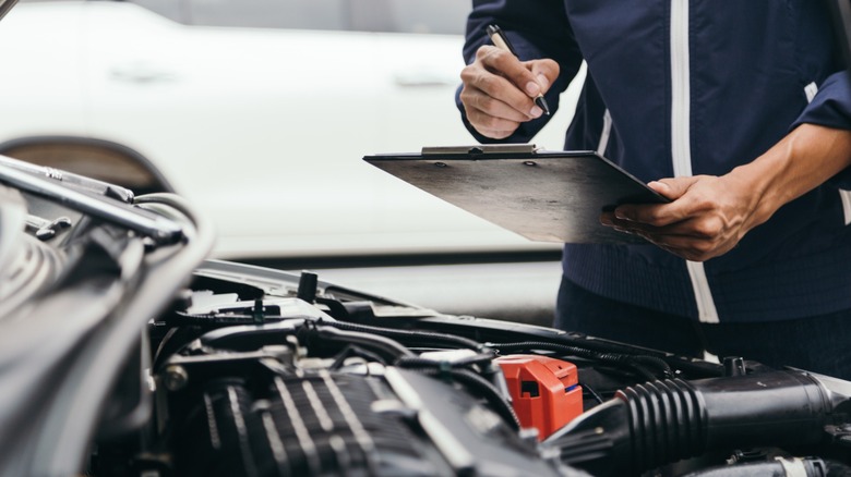 A zoomed in image of a person inspecting a vehicle