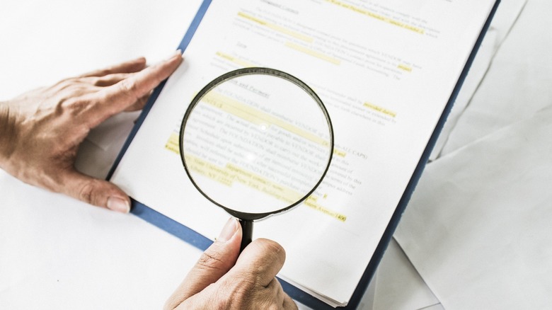 reading the fine print with a magnifying glass