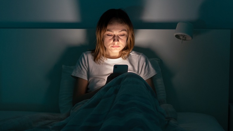 A person using a phone in a dark room