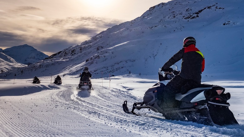 Snowmobiles riding on snowy terrain