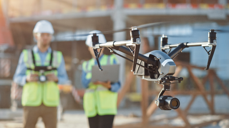 men wearing vest flying drone