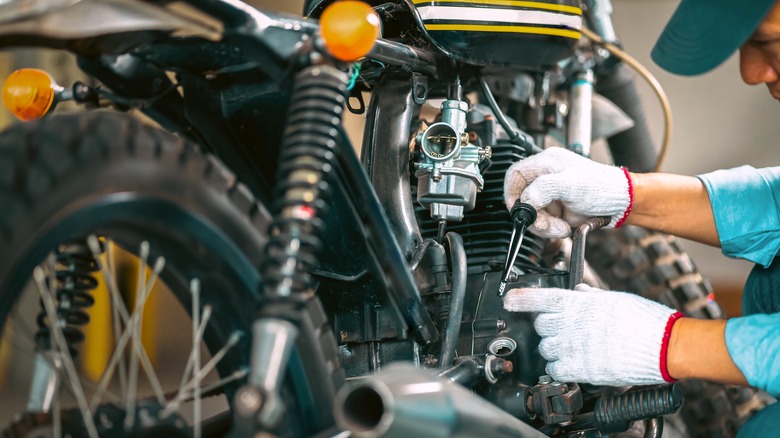 mechanic changing motorcycle oil