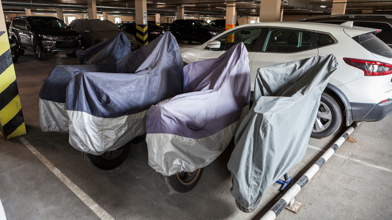 covered motorcycles in parking garage