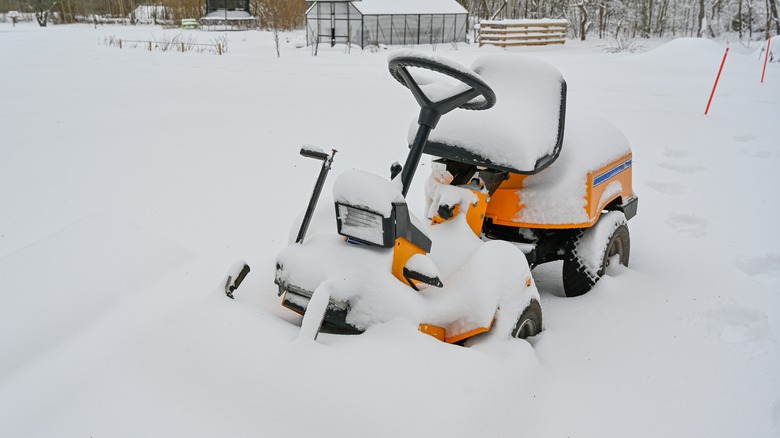 Riding mower covered in snow