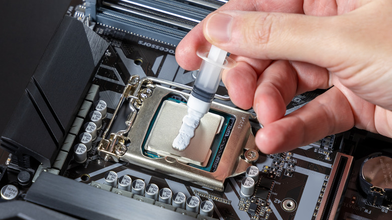 man applying thermal paste to cpu