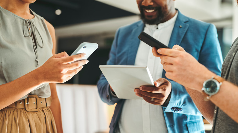 group of friends with phones and tablets