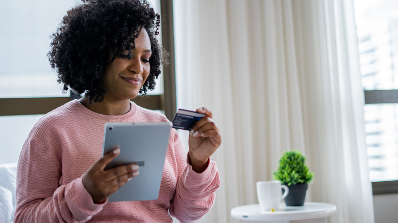 woman holding tablet and credit card