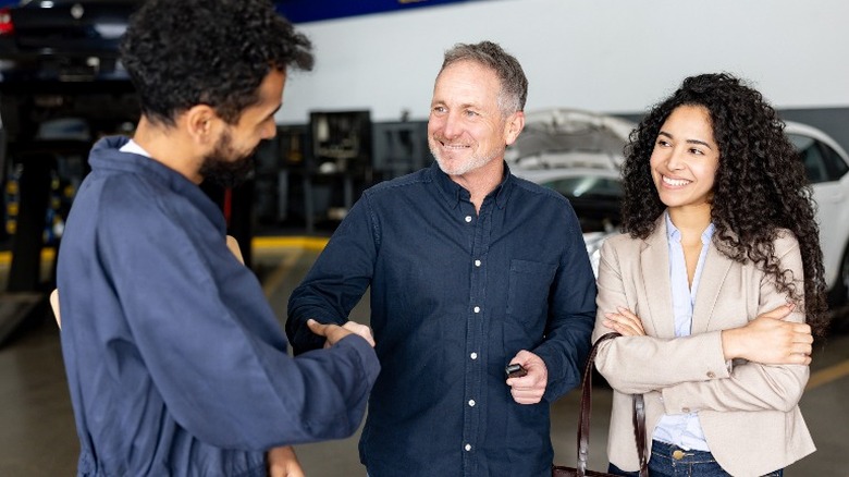 mechanic talking to couple