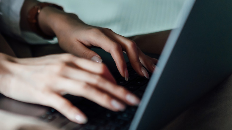 hands on laptop keyboard