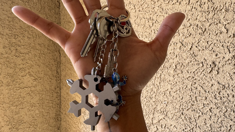 A set of keys that includes the BeTIM snowflake keychain is hanging from the author's finger