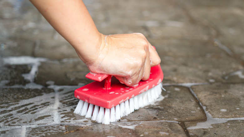 Scrubbing a hard brush on the floor