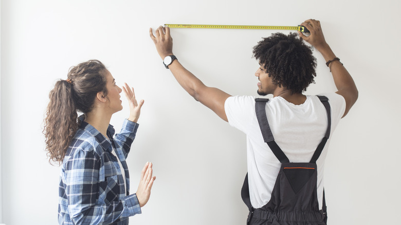 People measuring wall