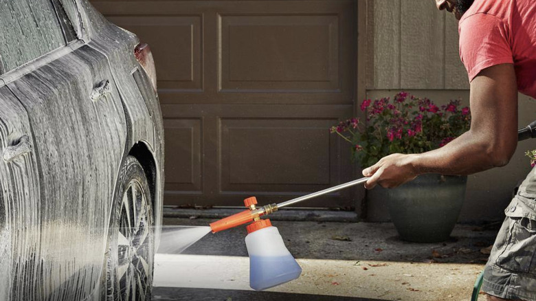 Man cleaning car with foam cannon