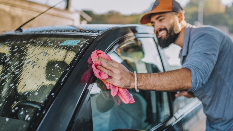 Man wiping car with cloth