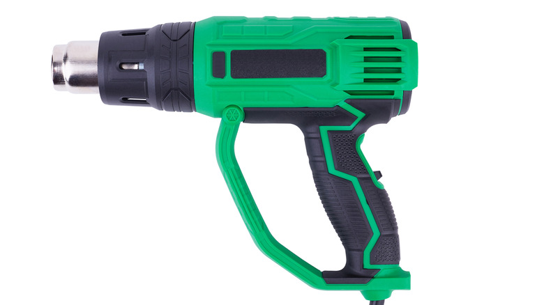 Green and black heat gun on plain background