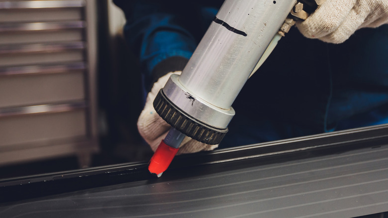 Sealant being applied on rubber seal in a factory