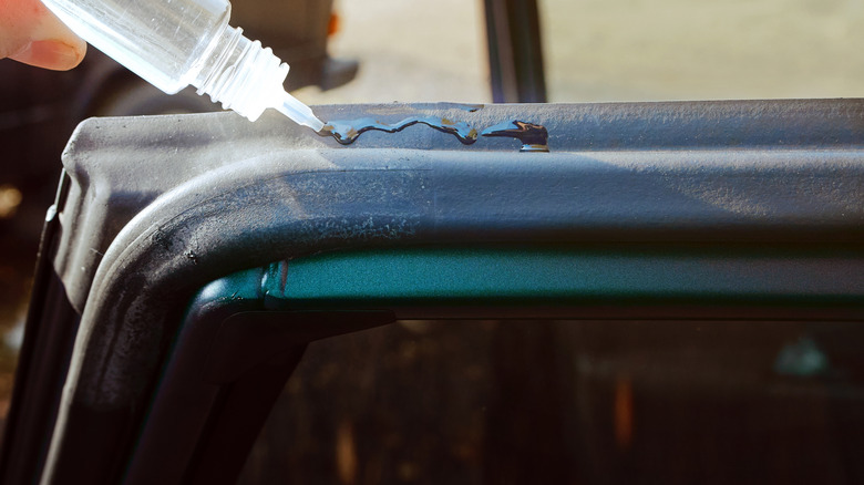 Sealant being applied to rubber seal on a car door