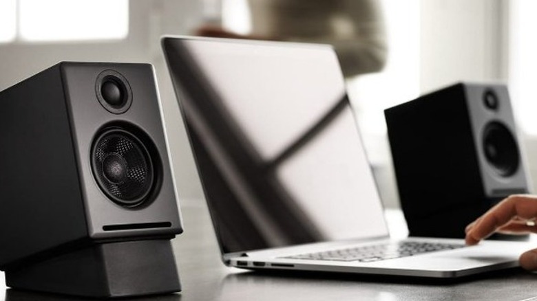 Speakers next to laptop on desk