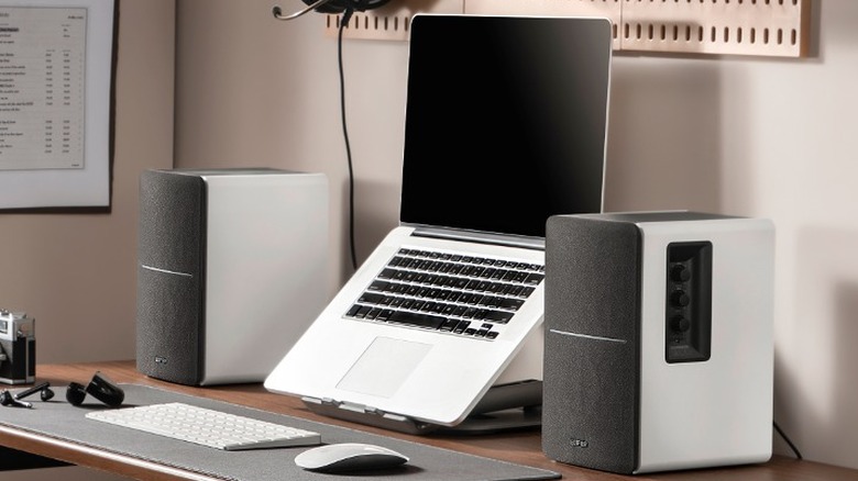 Speakers next to laptop on desk