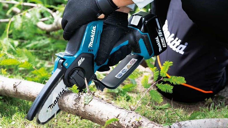 Makita pruning saw cutting a branch.