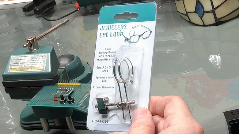 hand holding jewler's eye loop in package