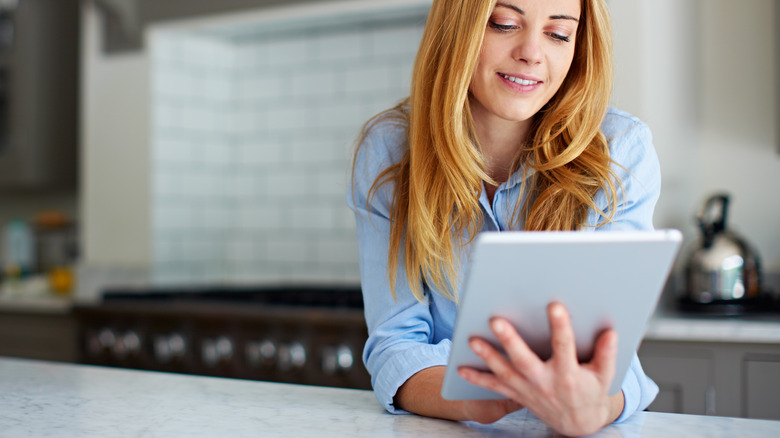 woman using tablet in kitchen