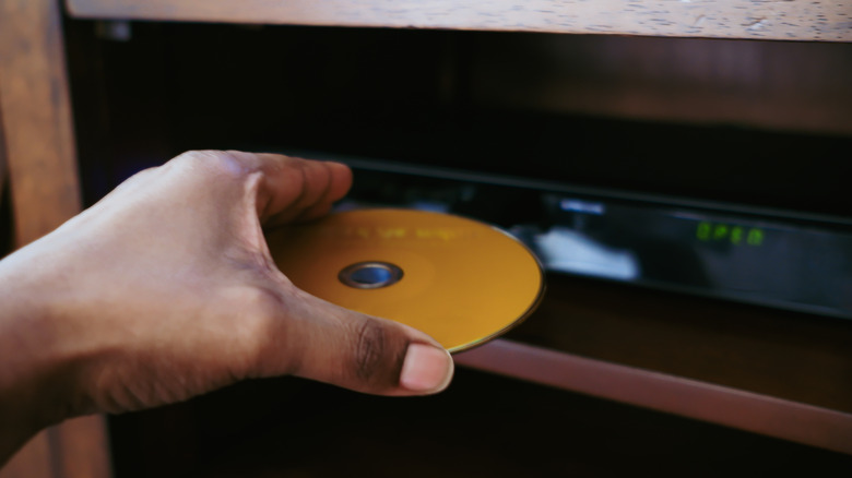 Hand feeding disk into DVD player