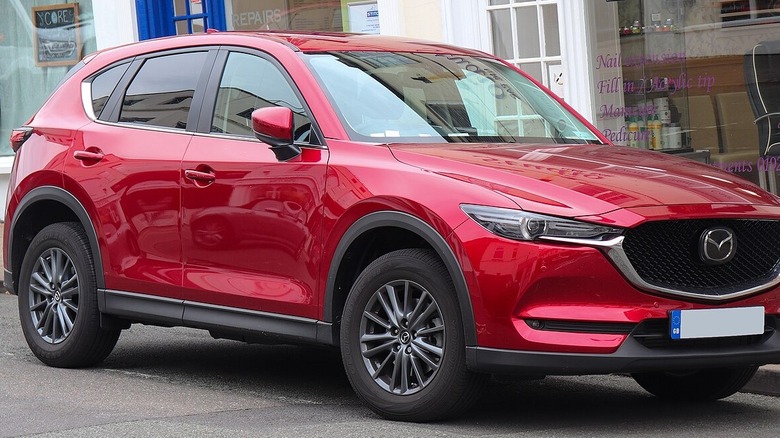 Red Mazda CX-5 parked on British street in front of spa