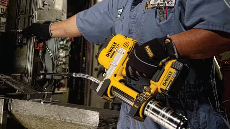 Worker using DeWalt grease gun