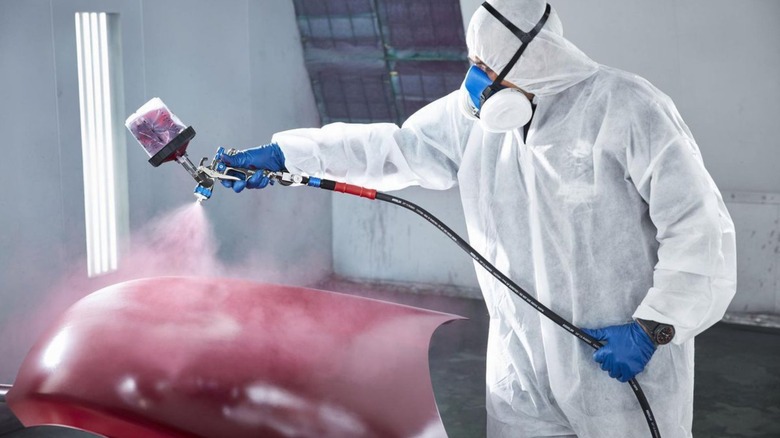 person painting with a paint sprayer