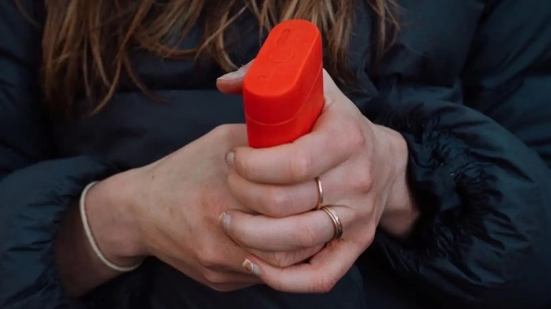 Person holding a red hand warmer