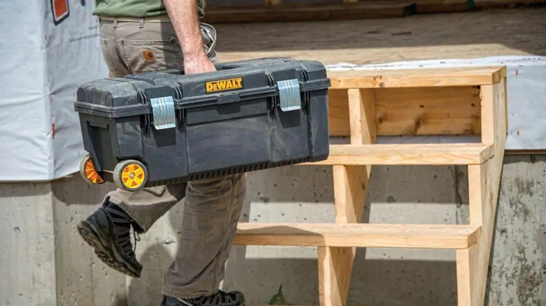 Worker carrying DeWalt rolling tool box