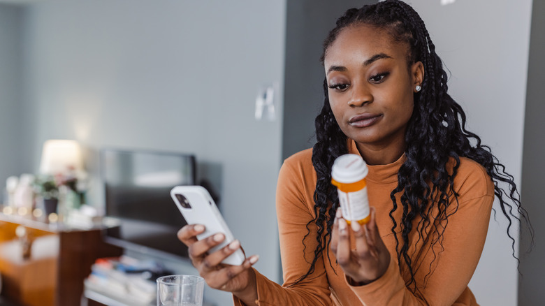 Woman checking phone about medicine