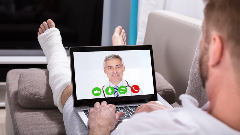 Person with broken leg using laptop