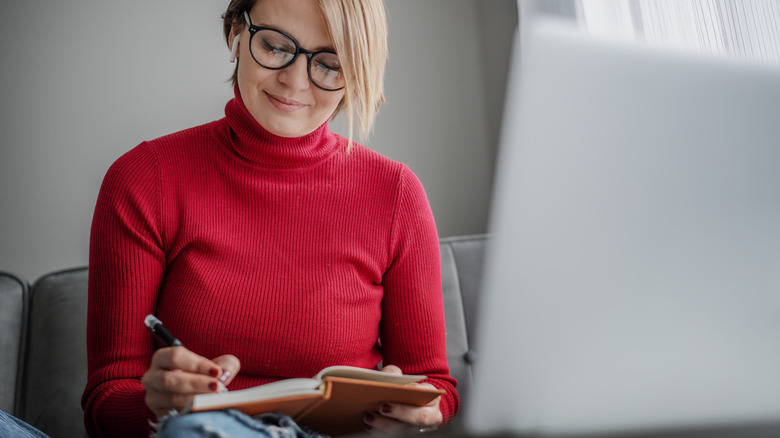 Psychologist writing and using laptop