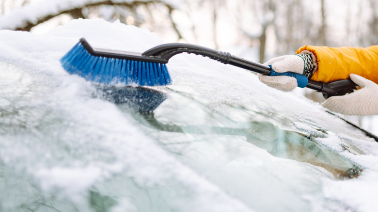 Woman cleaning icy windshield