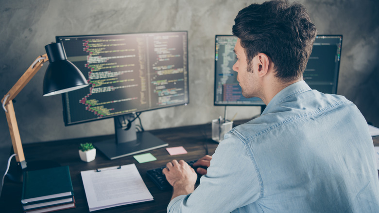 Person coding on desktop computer