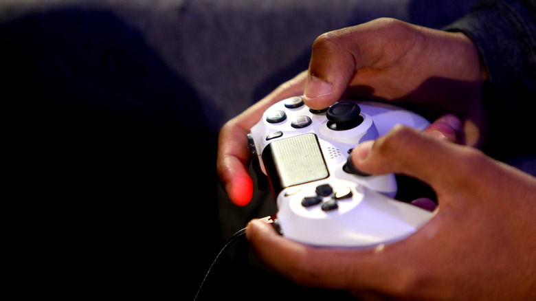 person using white PS4 controller