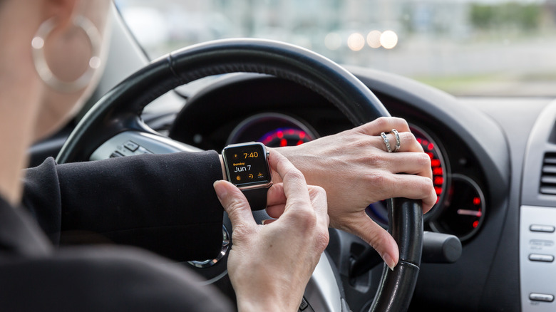 Person driving while looking at Apple Watch