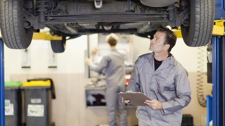 Mechanic examining a raised vehicle