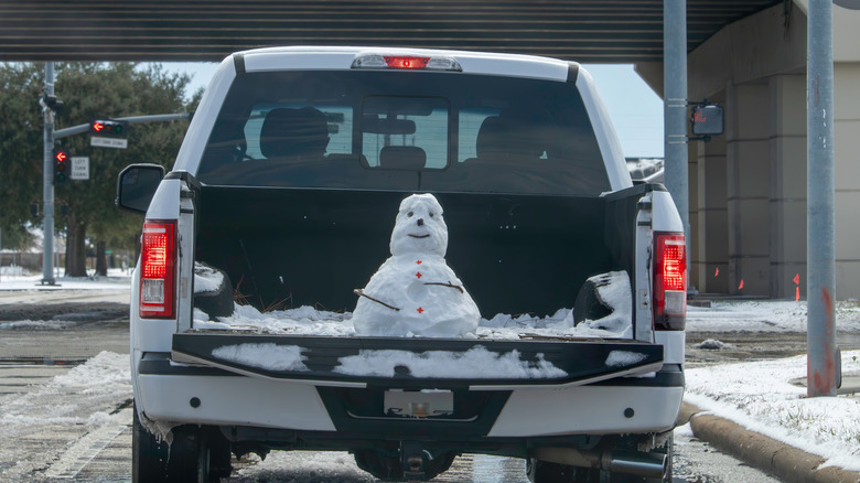 Snowman in back of pickup truck